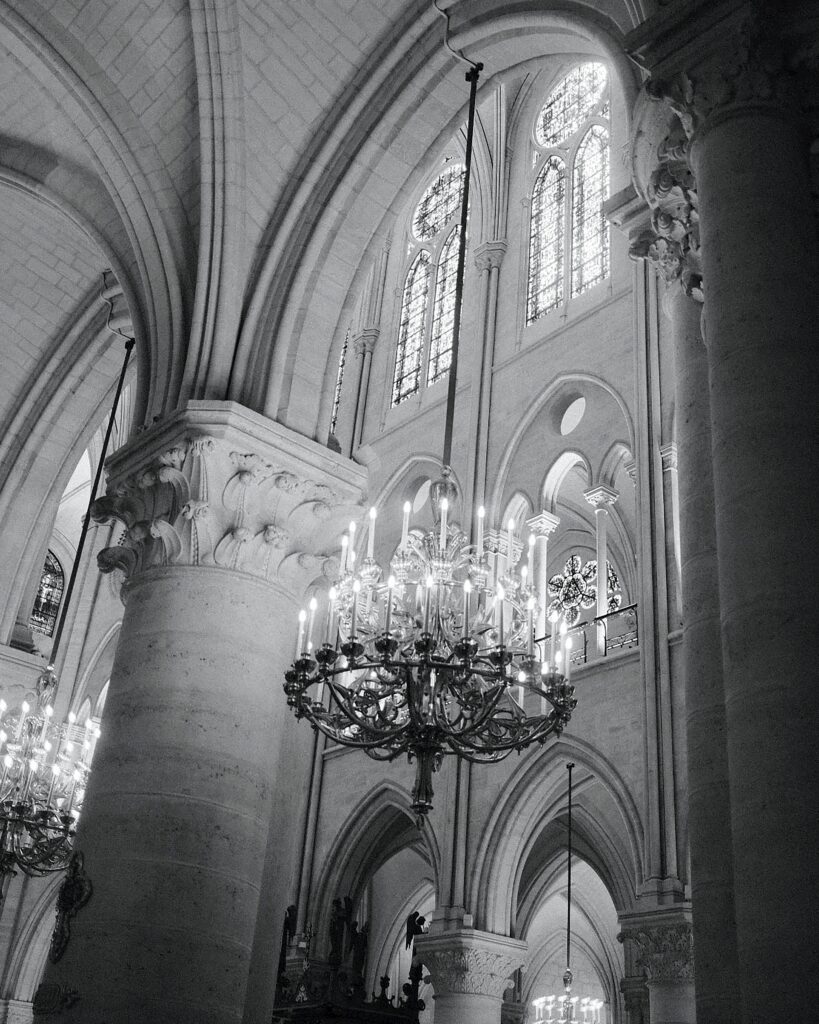 Interior view of Notre Dame de Paris showcasing its Gothic architecture and chandeliers.